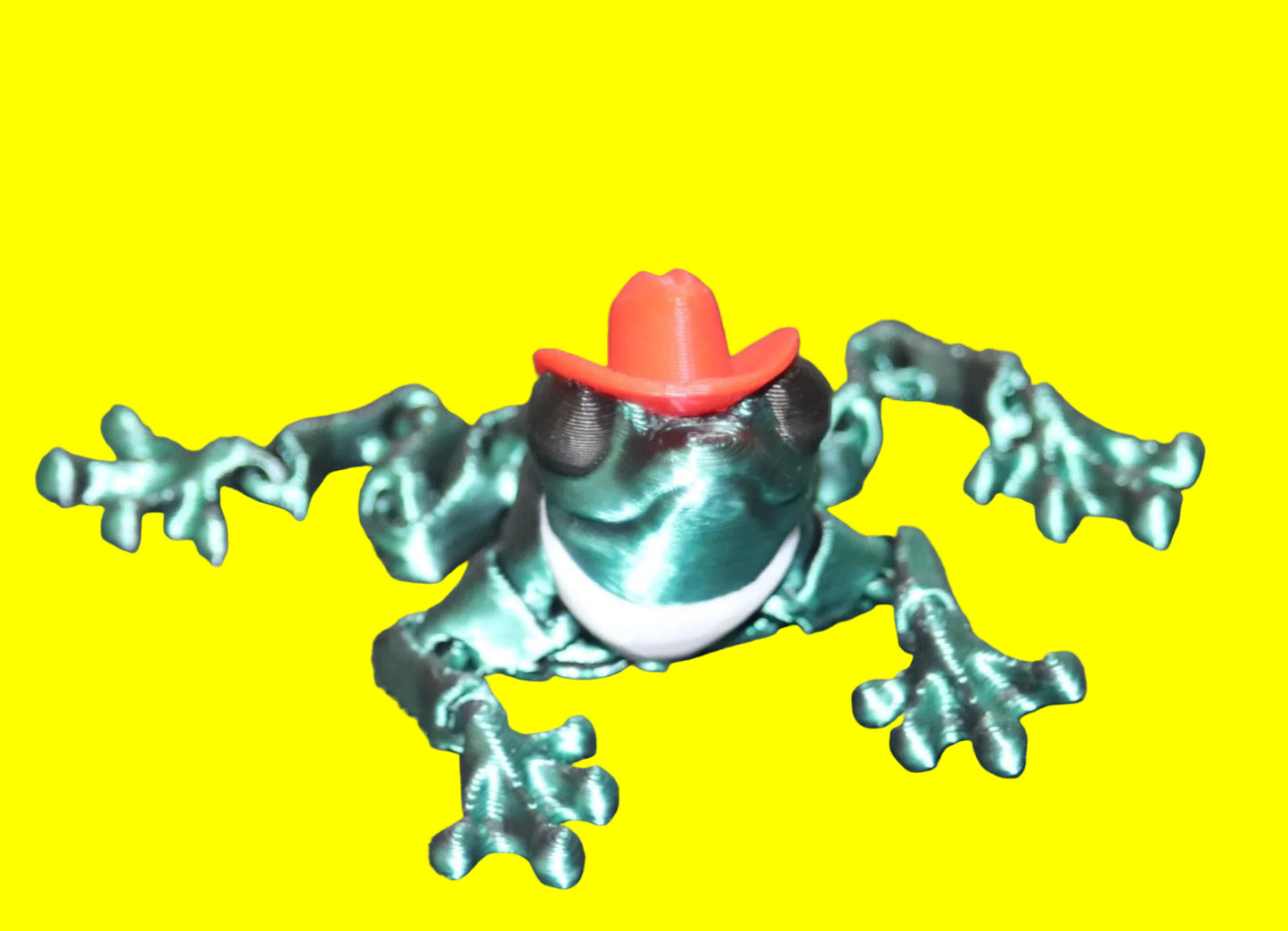 Frog figurine wearing a red cowboy hat on a dark background